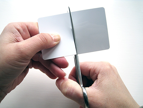 Cutting up a blank plastic credit card with scissors