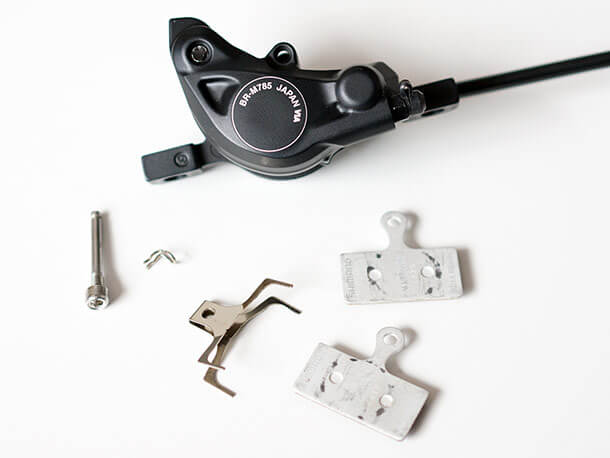 Shimano XT brake calliper with brake pads and retaining pin removed